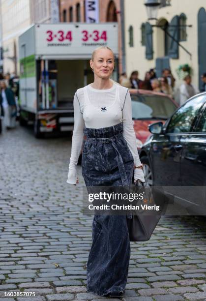 Thora Valdimars wears grey high waisted denim skirt, white long sleeve, grey Hermes bag outside Remain during the Copenhagen Fashion Week...