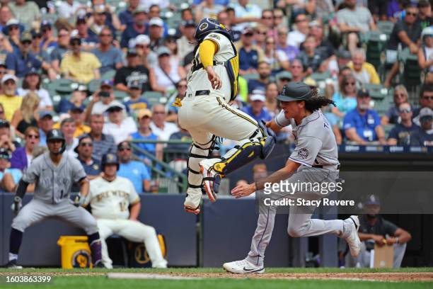 Cole Tucker of the Colorado Rockies is tagged out at home plate by William Contreras of the Milwaukee Brewers during the tenth inning of a game at...