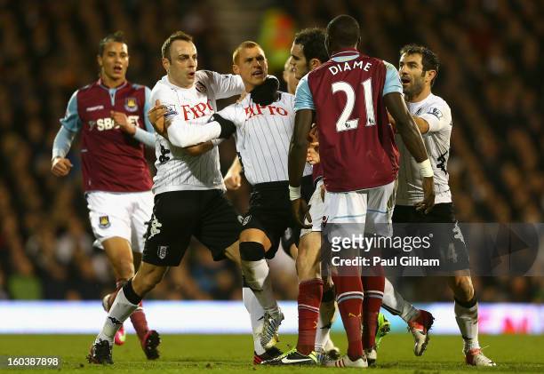 Steve Sidwell of Fulham is held back by team mate Dimitar Berbatov as he argues with Mohamed Diame of West Ham United during the Barclays Premier...
