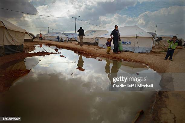Woman carries a gas canister as Syrian refugees go about their daily business in the Za’atari refugee camp on January 30, 2013 in Za'atari, Jordan....