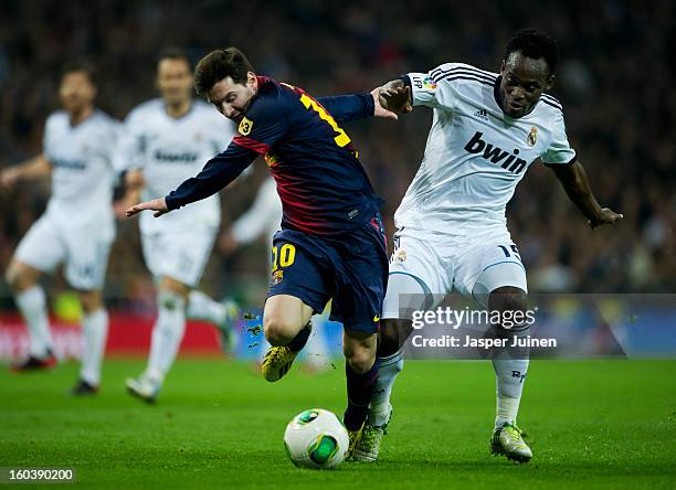 Lionel Messi of Barcelona duels for the ball with Michael Essien of Real Madrid during the Copa del Rey semi final first leg match between Real...