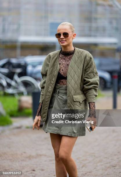 Guest wears green quilted jacket, skirt, laced black top outside OpéraSport during the Copenhagen Fashion Week Spring/Summer 2024 on August 09, 2023...