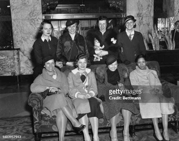 Indoor Track Championship athletes pose together in a hotel lobby. Seated L-R: Evelyn Ferrara, Genevieve Valvoda, Betty Robinson and Tiyde Pickett....