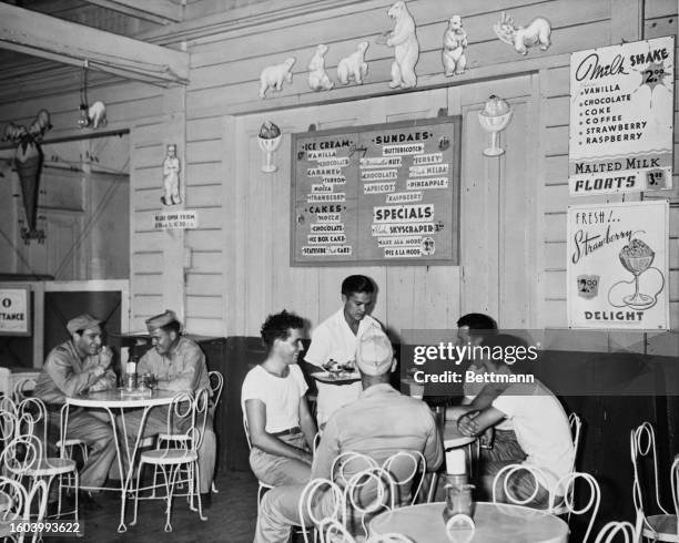 S sit down to enjoy a special treat at the Alaska Ice Cream Factory, Santa Mesa Blvd, Philippines, 9th March 1946.