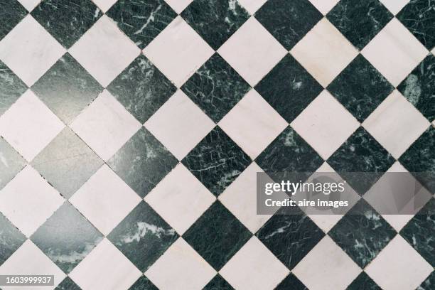 floor tile with black and white geometric patterns inside a house viewed from a high angle. - échiquier photos et images de collection