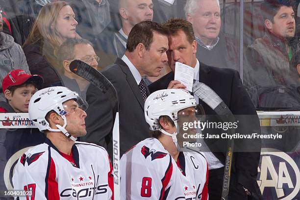 Assistant coach Calle Johansson talks with head coach Adam Oates of the Washington Capitals during an NHL game against the Ottawa Senators at...