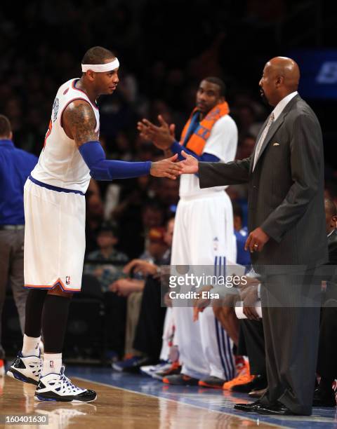 Carmelo Anthony of the New York Knicks is congratulated by head coach Mike Woodson after Anthony was pulled from the game against the Orlando Magic...