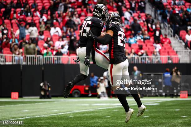 Deion Jones of the Atlanta Falcons celebrates with Erik Harris after forcing a fumble during an NFL game against the Carolina Panthers at...
