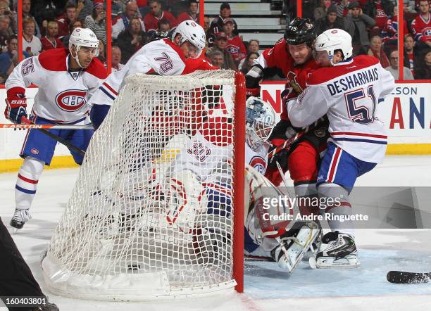 The puck sits in the net behind Peter Budaj of the Montreal Canadiens for a third period goal as Zack Smith of the Ottawa Senators crashes the net...