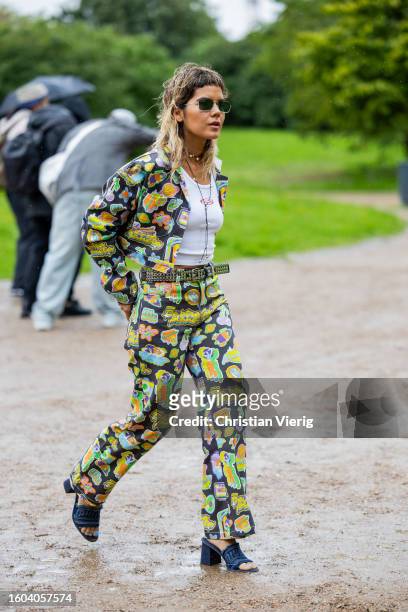 Guest wears pants and cropped jacket with floral print outside OpéraSport during the Copenhagen Fashion Week Spring/Summer 2024 on August 09, 2023 in...