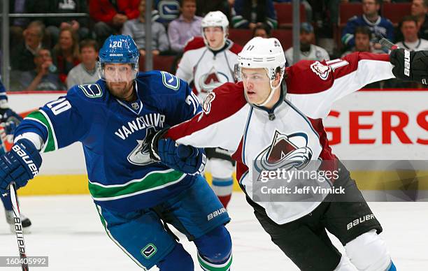 Chris Higgins of the Vancouver Canucks holds onto Jamie McGinn of the Colorado Avalanche during their NHL game at Rogers Arena January 30, 2013 in...