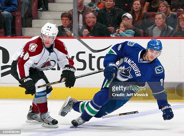 Christopher Tanev of the Vancouver Canucks breaks his stick in a collision with Mark Olver of the Colorado Avalanche during their NHL game at Rogers...
