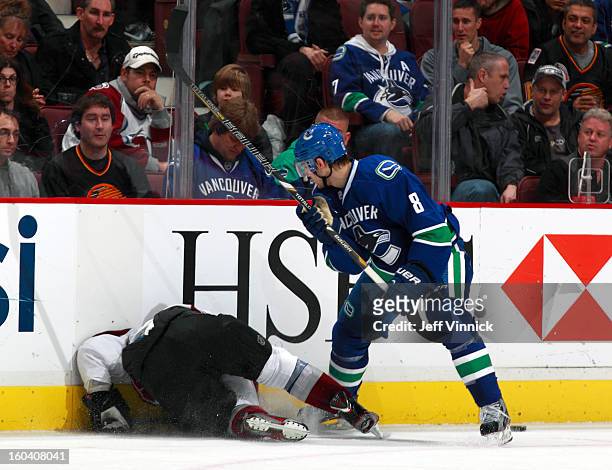 Christopher Tanev of the Vancouver Canucks boards P.A. Parenteau of the Colorado Avalance and receives a penalty during their NHL game at Rogers...
