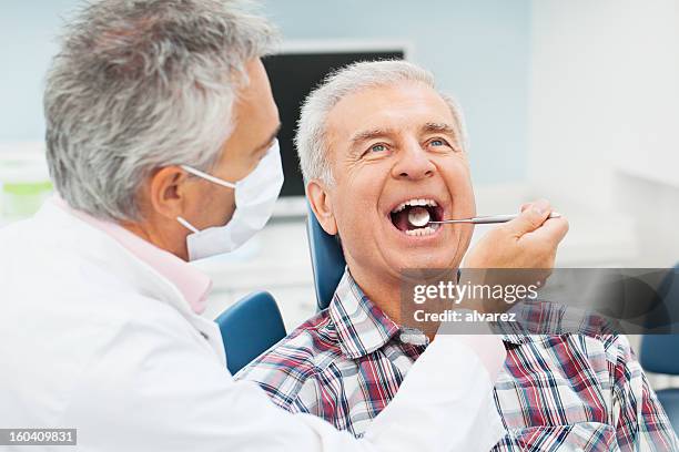 senior mann beim zahnarzt - dental care stock-fotos und bilder