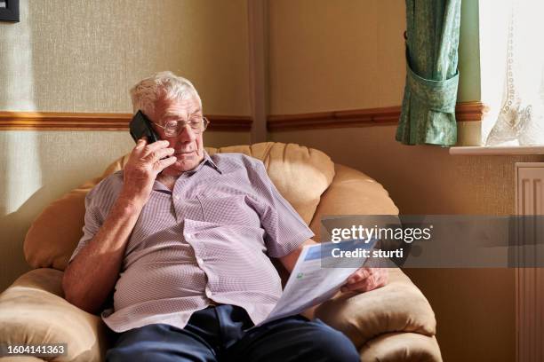 senior man querying a bill - helping people stock pictures, royalty-free photos & images