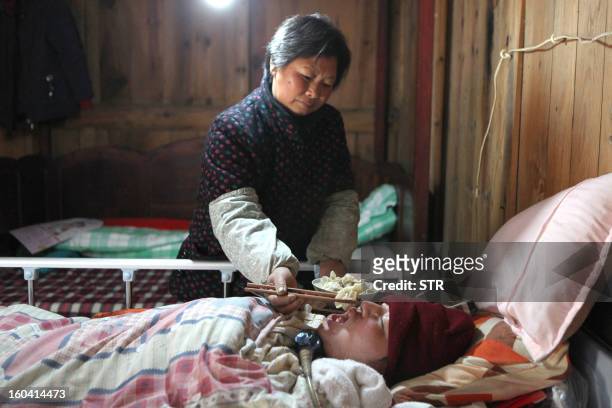 This picture taken on January 28, 2013 shows Fu Xuepeng, a former mechanic who was paralyzed in a road accident when he was 23 years old, breathing...