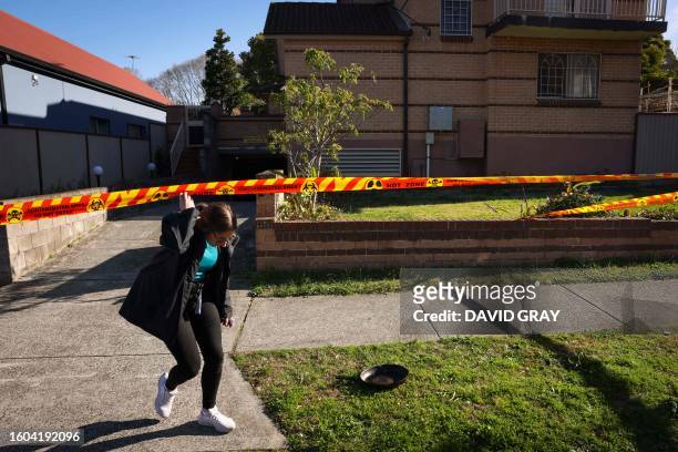 An Australian Border Force agent walks under safety tape outside an apartment block after they raided it earlier amid media reports "nuclear...