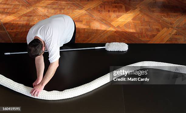 Frohmut Zscheckel helps artist Joan Sallas put the finishing touches to a 3 metre folded linen snake they are displaying as part of a new exhibition...