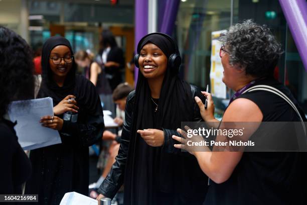 Student Rayaan Mahamoud celebrates her A-Level results with a member of teaching staff at City of London Academy on August 17, 2023 in London,...