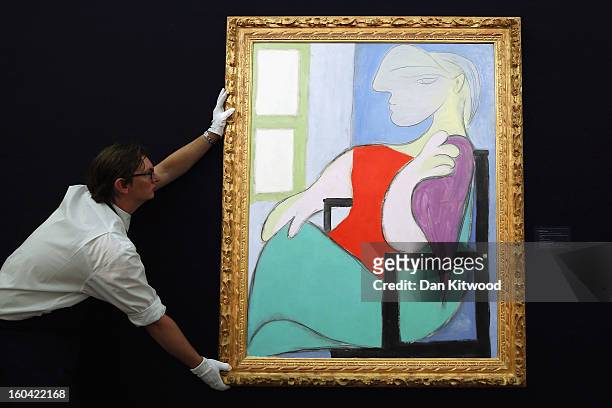 Sotheby's employee poses with a painting by Pablo Picasso entitled 'Femme assise pres d' une fenetre,' 1932, on January 31, 2013 in London, England....