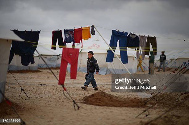 Syrian boy collects water in the Za’atari refugee camp on January 31, 2013 in Za'atari, Jordan. Record numbers of refugees are fleeing the violence...