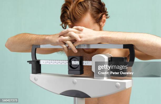 distraught man with eating disorder - male anorexia photos et images de collection