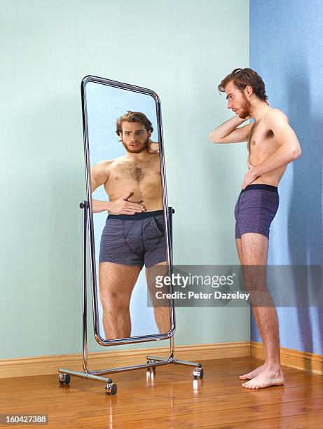 anorexic man looking at himself in mirror - body dysmorphia stock pictures, royalty-free photos & images
