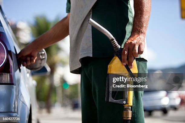 An attendant fills a vehicle's gas tank at a Petroleo Brasileiro SA station in Rio de Janeiro, Brazil, on Thursday, Jan. 31, 2013. State-controlled...