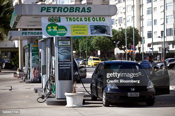 Customer pays an attendant at a Petroleo Brasileiro SA station in Rio de Janeiro, Brazil, on Thursday, Jan. 31, 2013. State-controlled oil company...