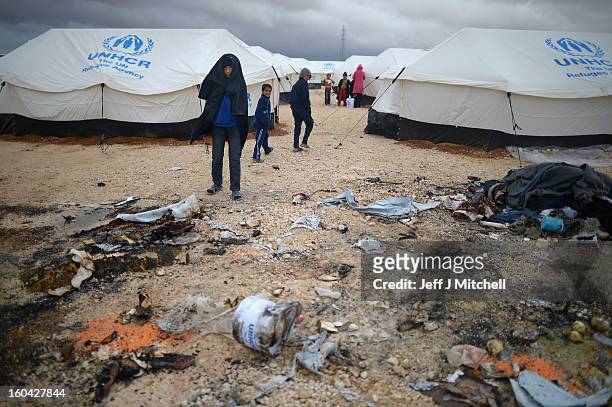 Syrian look at a tent burned down in the Za’atari refugee camp on January 31, 2013 in Za'atari, Jordan. Record numbers of refugees are fleeing the...