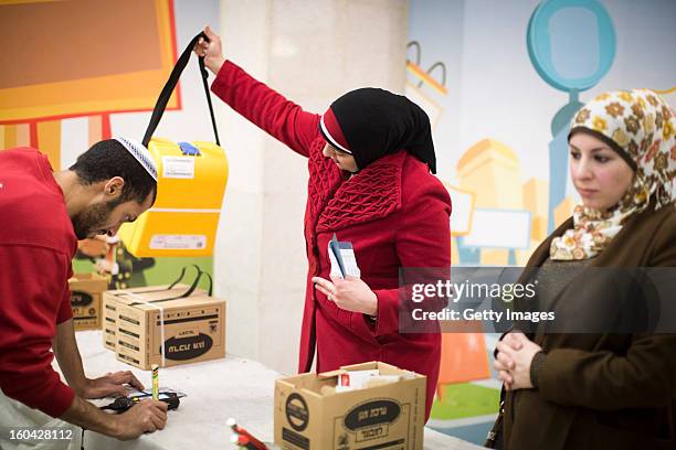 Israeli Arabs collect gas mask kits from a distribution station in a mall January 31 in Pisgat Ze'ev, East Jerusalem, Israel. Israel remains on high...