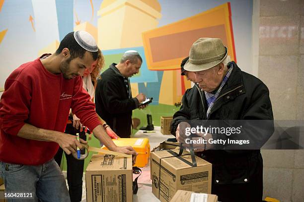 An Israeli man collects gas mask kits from a distribution station in a mall January 31 in Pisgat Ze'ev, East Jerusalem, Israel. Israel remains on...