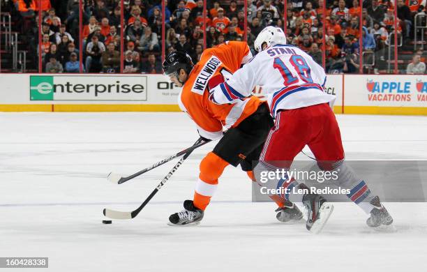 Eric Wellwood of the Philadelphia Flyers skates the puck against Marc Staal of the New York Rangers on January 24, 2013 at the Wells Fargo Center in...