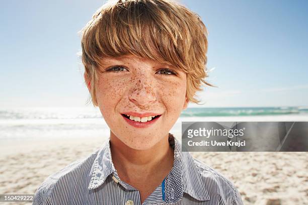 portrait of young boy at beach - boy freckle stock pictures, royalty-free photos & images