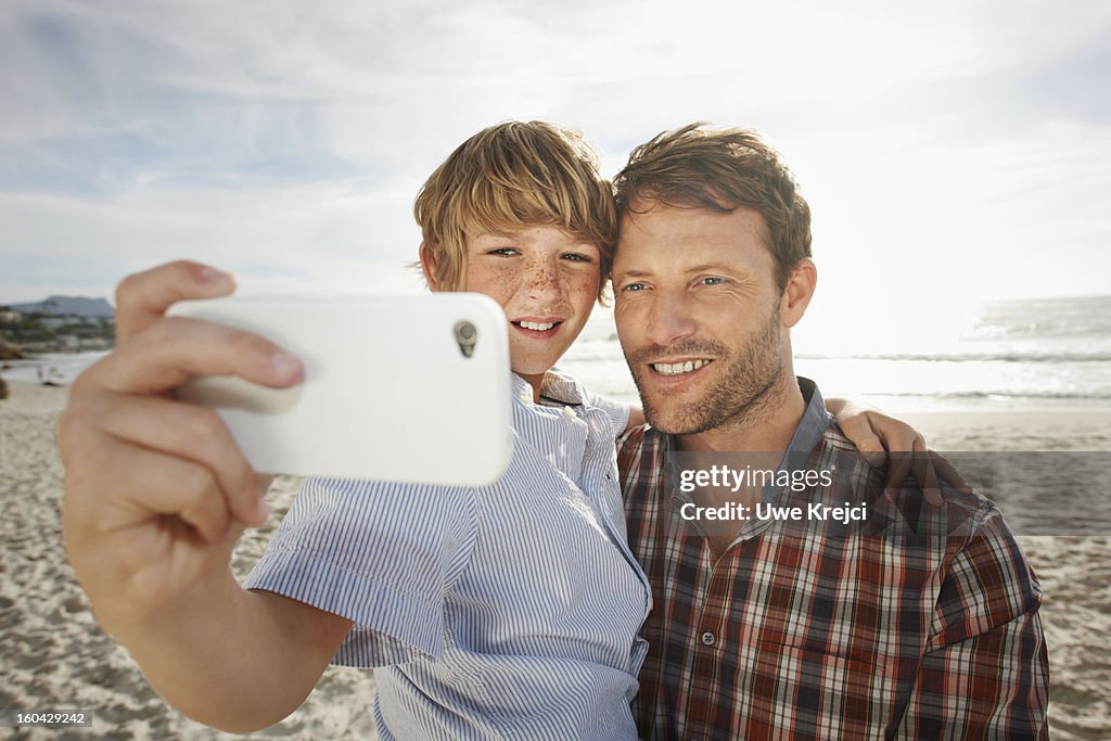 Father and son taking self-portrait, outdoors