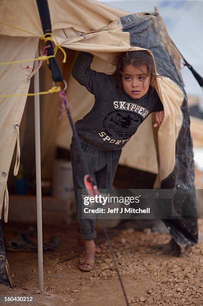 Young Syrian girl looks out from a tent in the Za’atari refugee camp on January 31, 2013 in Za'atari, Jordan. Record numbers of refugees are fleeing...