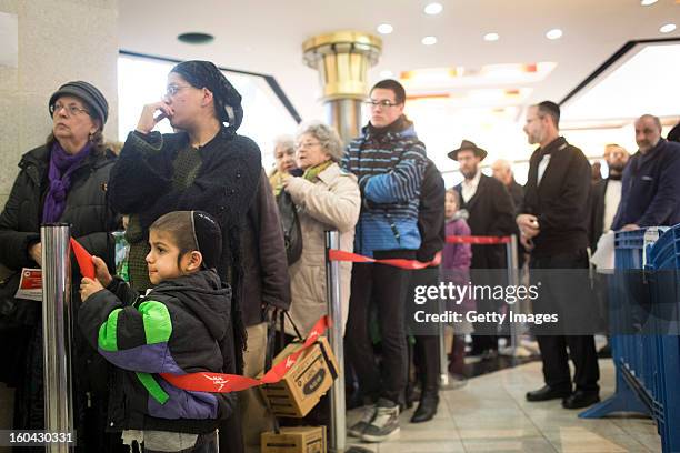 Israelis wait in a line to collect gas mask kits from a distribution station in a mall January 31 in Pisgat Ze'ev, East Jerusalem, Israel. Israel...