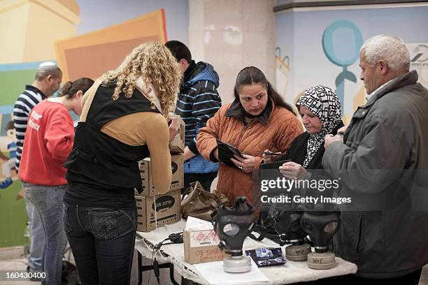 Israelis collect gas mask kits from a distribution station in a mall January 31 in Pisgat Ze'ev, East Jerusalem, Israel. Israel remains on high alert...