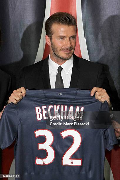 International soccer player David Beckham poses with his PSG Football shirt after his PSG signature at Parc des Princes on January 31, 2013 in Paris,...