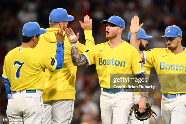 Alex Verdugo of the Boston Red Sox high fives Masataka Yoshida after a game against the Kansas City Royals at Fenway Park on August 09, 2023 in...