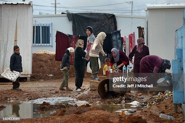 Syrian children gather round women washing in the Za’atari refugee camp on January 31, 2013 in Za'atari, Jordan. Record numbers of refugees are...