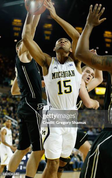 Jon Horford of the Michigan Wolverines gets a shot off around Donnie Hale of the Purdue Boilermakers during the first half at Crisler Center on...