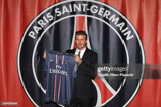 International soccer player David Beckham poses with his PSG Football shirt after his PSG signature at Parc des Princes on January 31, 2013 in Paris,...