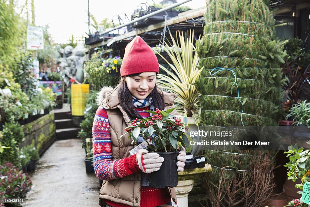 Woman choosing plant in gardencentre.