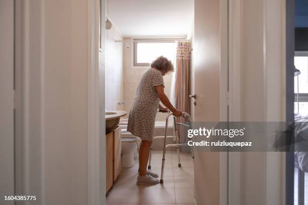 femme âgée handicapée dans la salle de bain - adaptation photos et images de collection