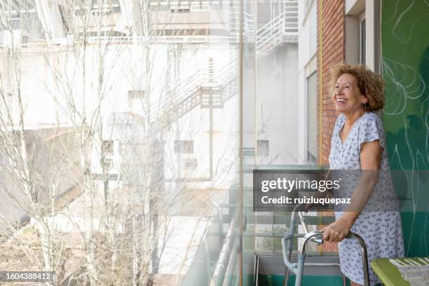 portrait of an elderly disabled woman on her balcony - hip surgery stock pictures, royalty-free photos & images