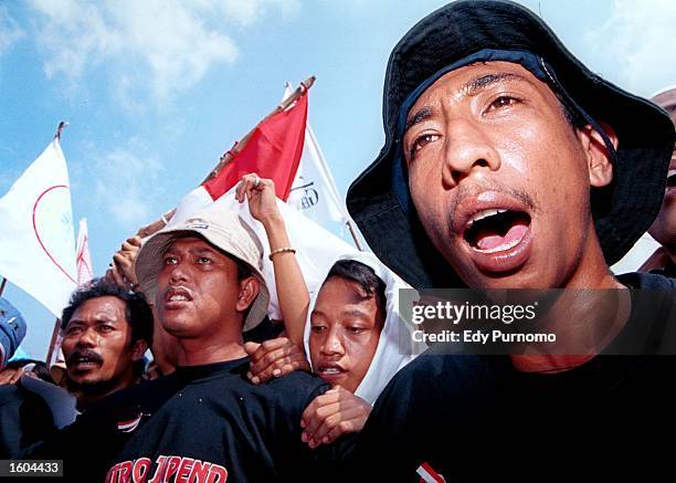 Supporters of deposed Indonesian President Abdurrahman Wahid shout slogans while waiting for Wahid to give a speech upon leaving the presidential...