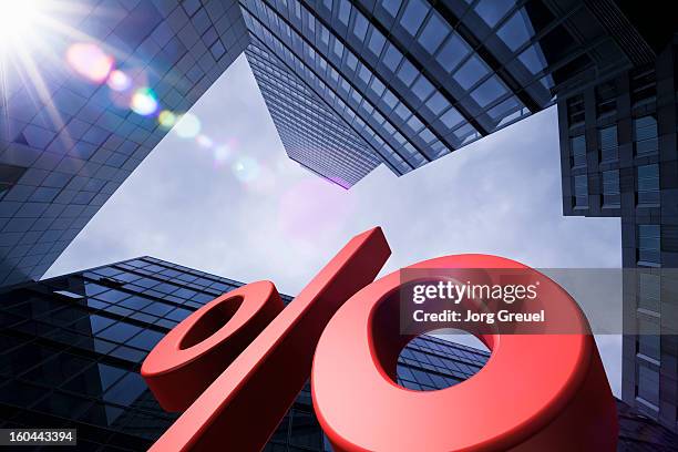 giant percent sign and office buildings - percentage sign stock-fotos und bilder