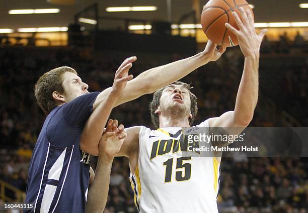 Forward Zach McCabe of the Iowa Hawkeyes grabs a rebound during the first half in front of forward Donovan Jack of the Penn State Nittany Lions on...