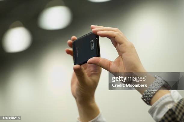 An attendee takes a photo using a Samsung Electronics Co. Smartphone at the Macworld/iWorld conference at the Moscone Center West in San Francisco,...